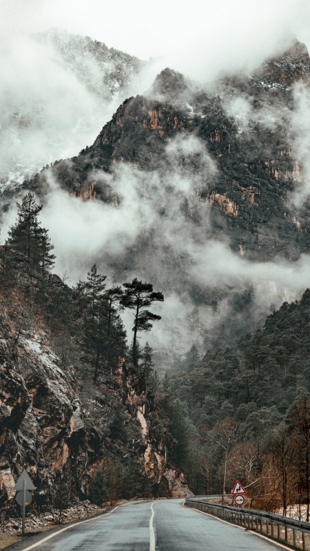 云雾缭绕山间公路灰绿风景手机壁纸
