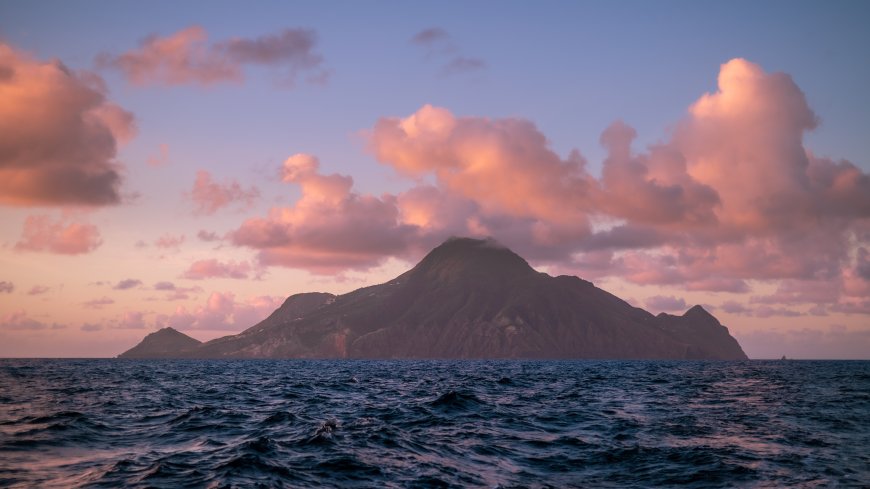 火山岛海面日落粉紫风景电脑壁纸