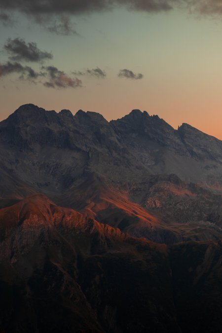 夕阳染红山峦层叠起伏暖橙风景手机壁纸
