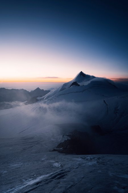 雪山巍峨云雾缭绕蓝紫渐变风景手机壁纸