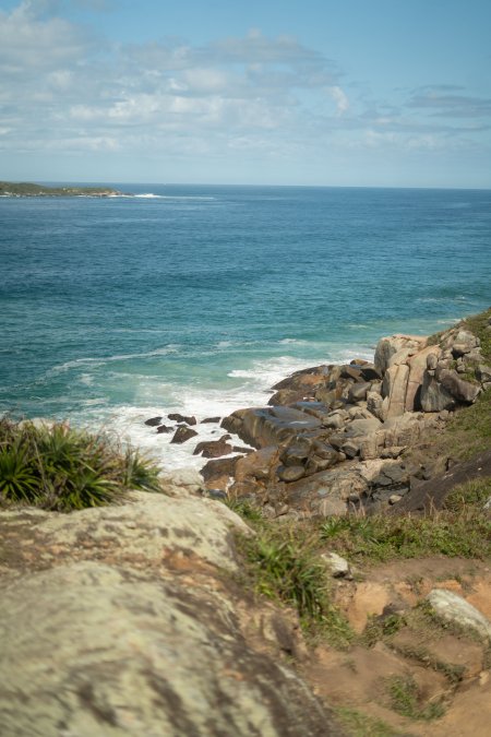 海岸礁石海浪拍打蓝绿风景手机壁纸