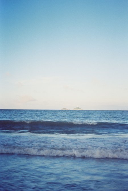 海面波浪轻涌远岛淡蓝风景手机壁纸