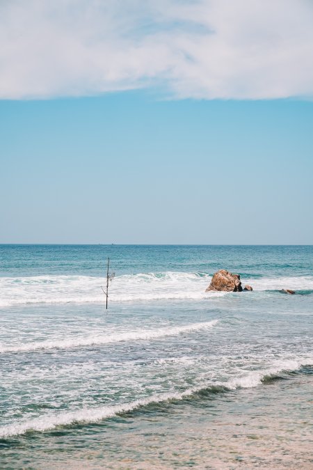 海边礁石浪花拍岸蓝白风景手机壁纸