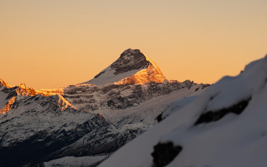 雪山巍峨峰顶镀金霞光暖橙风景电脑壁纸