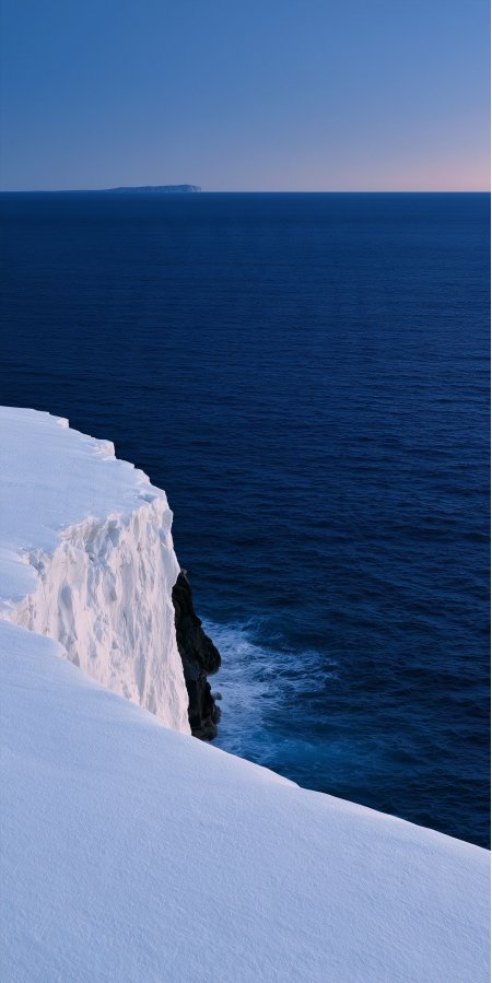 冰雪悬崖临海矗立深蓝海洋远岛轮廓蓝白风景手机壁纸
