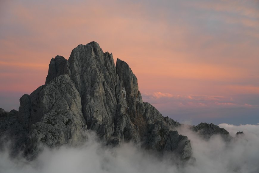 巍峨岩峰云海缭绕粉紫渐变风景电脑壁纸