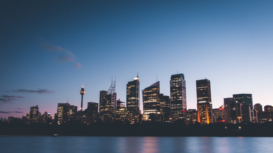 悉尼歌剧院旁高楼林立夜景蓝紫城市建筑电脑壁纸