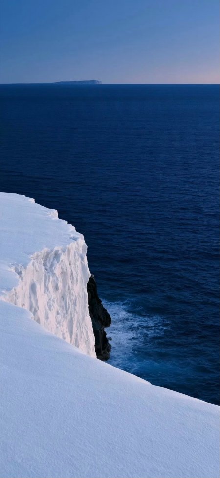 冰雪悬崖临海矗立深蓝海洋远岛静谧蓝白自然风景手机壁纸