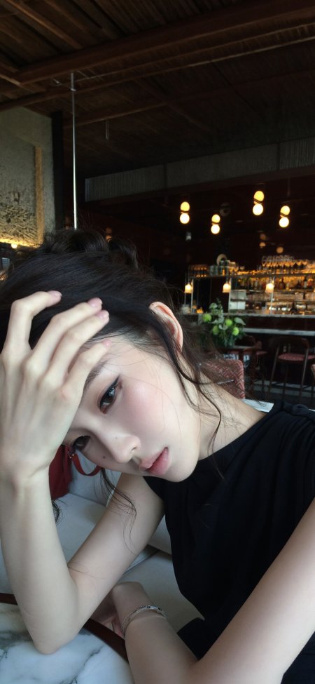 黑发美女手抚额侧颜温柔暖调美女手机壁纸