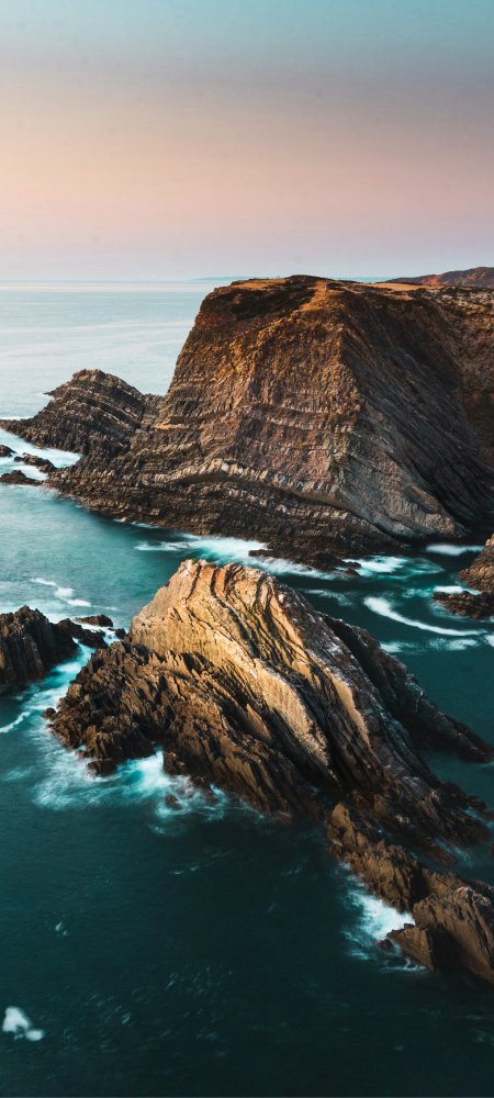 壮丽海蚀崖层叠岩壁碧海白浪蓝粉渐变自然风景手机壁纸