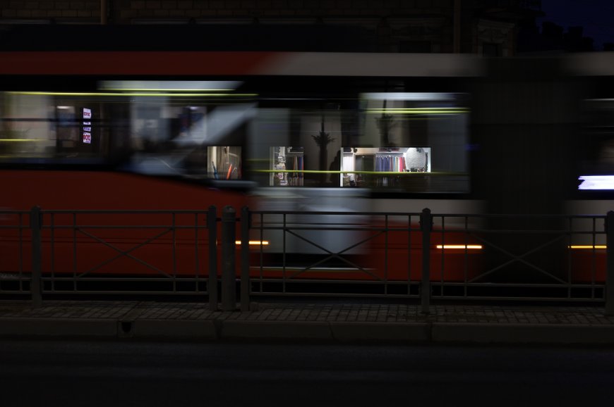 夜色中红色电车疾驰而过光影流动暗调城市建筑电脑壁纸