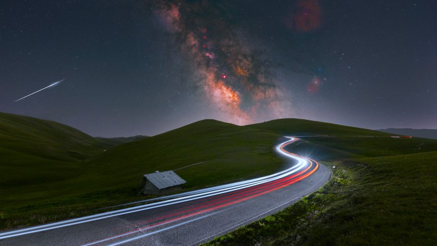 银河拱桥下蜿蜒山路车灯轨迹绿野星空暗紫自然风景电脑壁纸