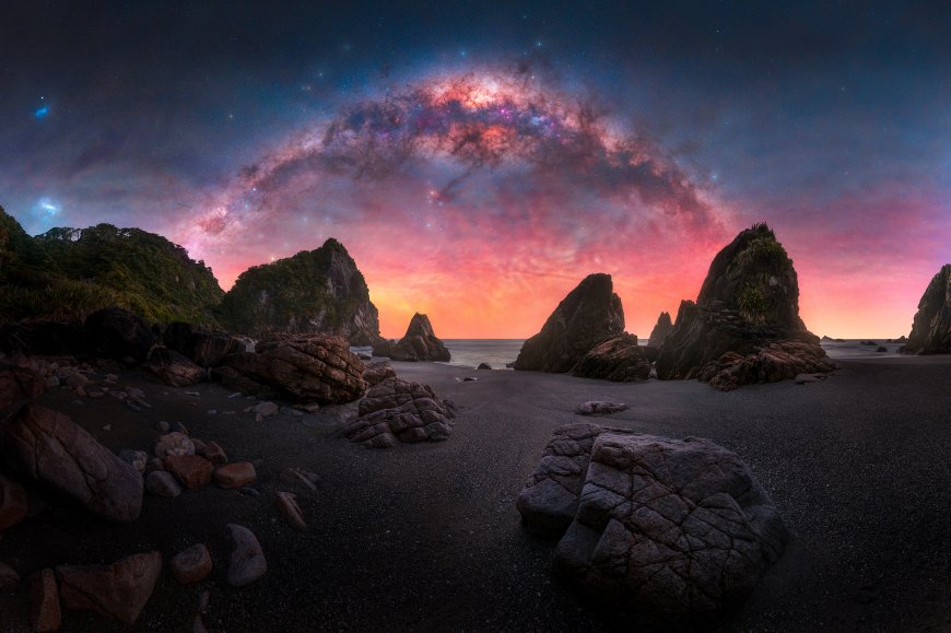 银河拱桥横跨海岸岩群粉紫渐变星空自然风景电脑壁纸