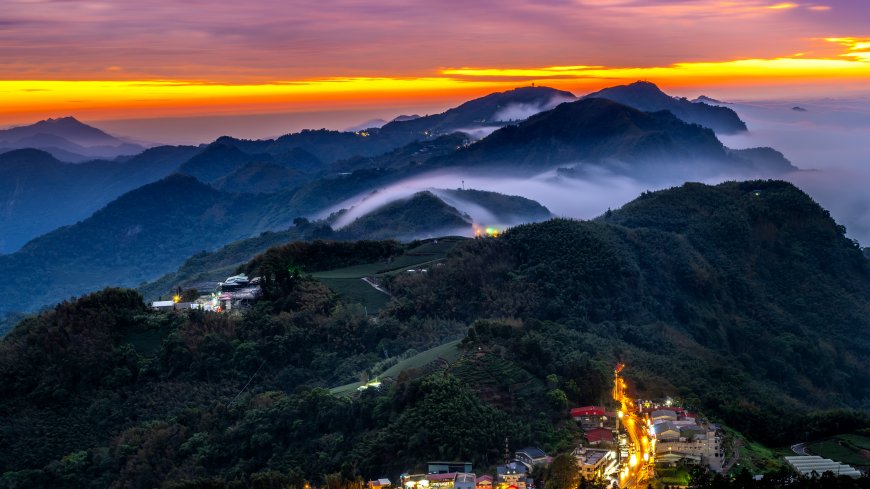层峦叠嶂云海缭绕山间村落灯火暖金自然风景电脑壁纸