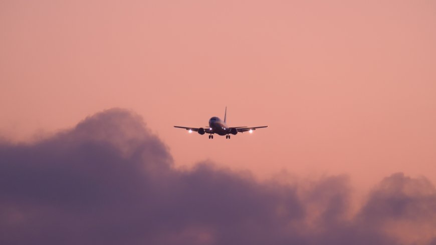 民航客机穿云而过粉紫渐变天空摄影电脑壁纸