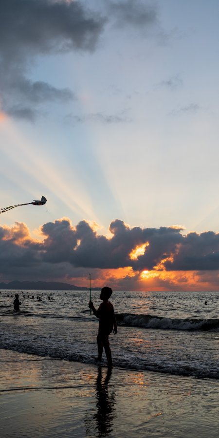 海边夕阳下孩童放风筝剪影橙金人文风土手机壁纸