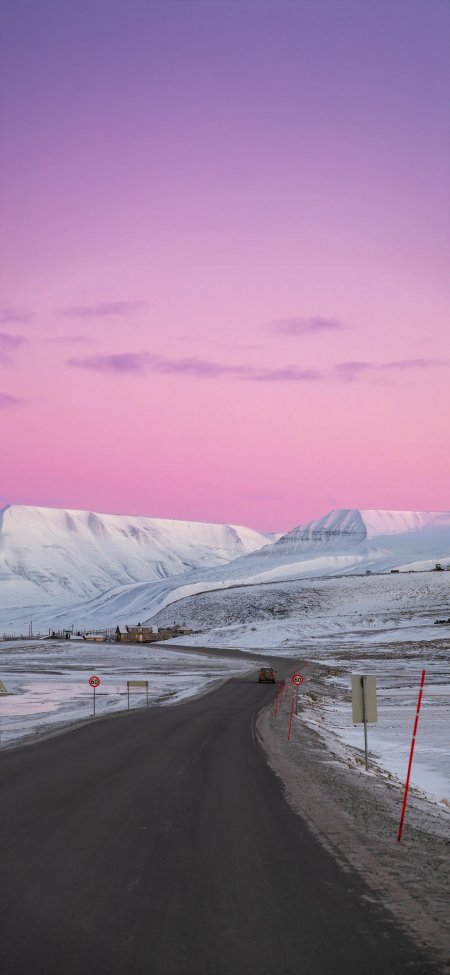 雪山公路蜿蜒延伸粉紫渐变天空下雪原小屋静谧风景手机壁纸