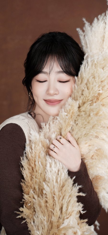 杨紫闭眼微笑怀抱蒲苇暖棕明星大咖手机壁纸