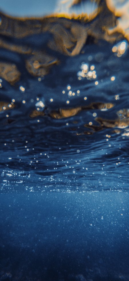 深蓝海水波光粼粼气泡浮动暖金蓝调自然风景手机壁纸