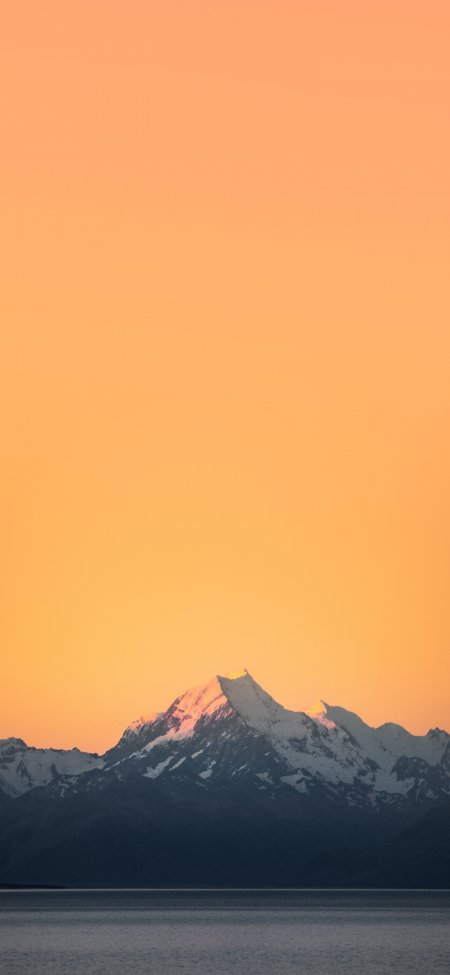 雪山巍峨倒影湖面橙金暖调自然风景手机壁纸