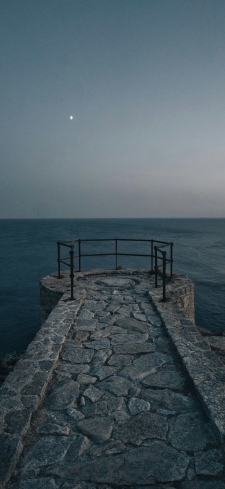 石砌海堤尽头铁栏望月深蓝静谧风景手机壁纸