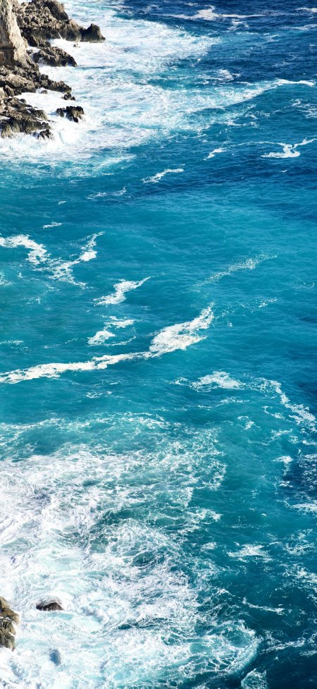 蔚蓝海浪拍打嶙峋礁石白沫飞溅蓝白自然风景手机壁纸