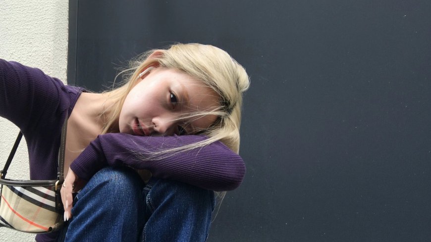 金发美女紫衣倚墙侧颜浅笑暖调人物摄影电脑壁纸