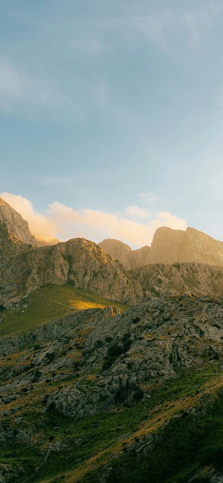 巍峨山峦层叠起伏晨光洒落金边蓝白自然风景手机壁纸