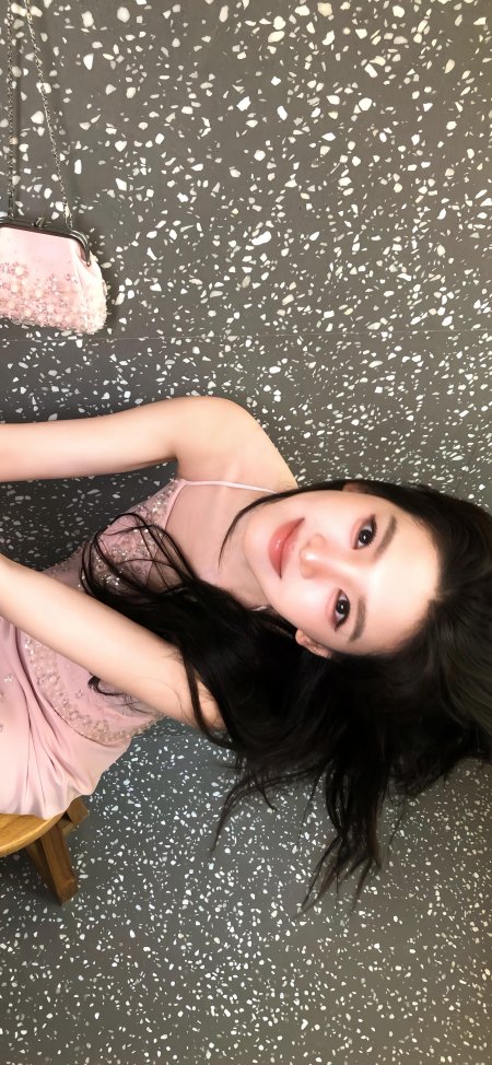 长发黑发粉裙美女微笑躺姿暖粉人物摄影手机壁纸